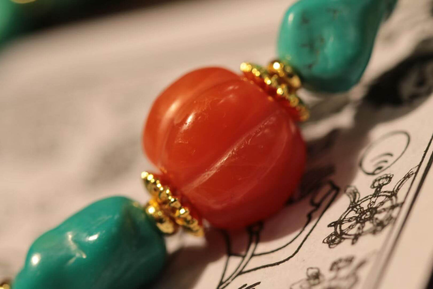 Turquoise bracelet with south red agate featuring vibrant gem beads and gold accents.